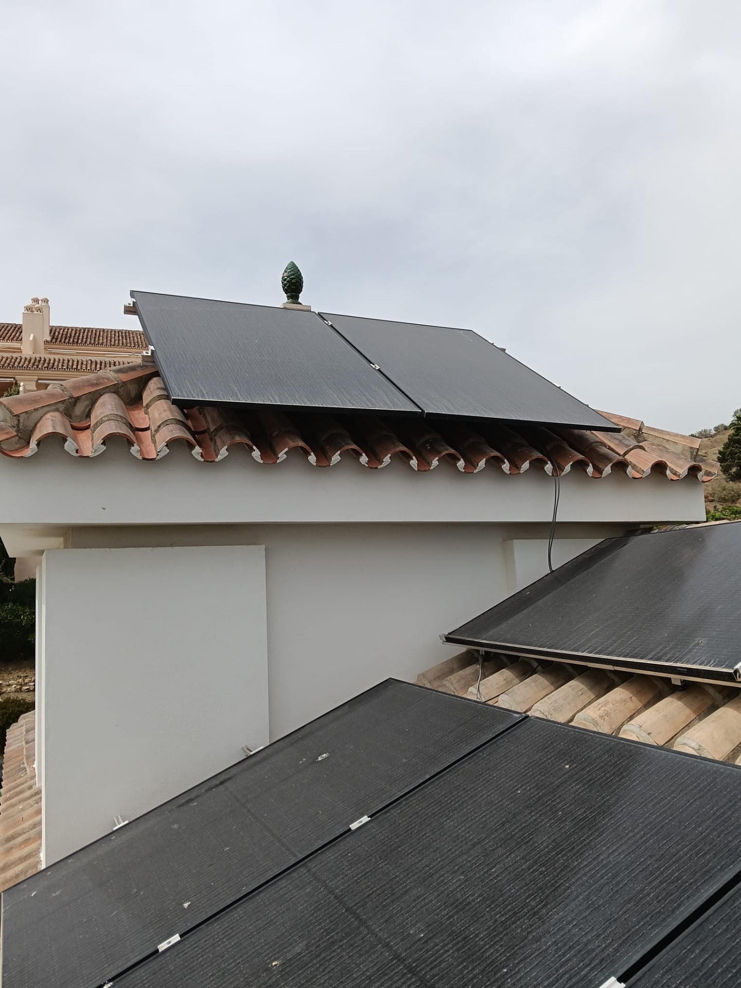 Solar panel cleaning in progress on a barrel-tile roof