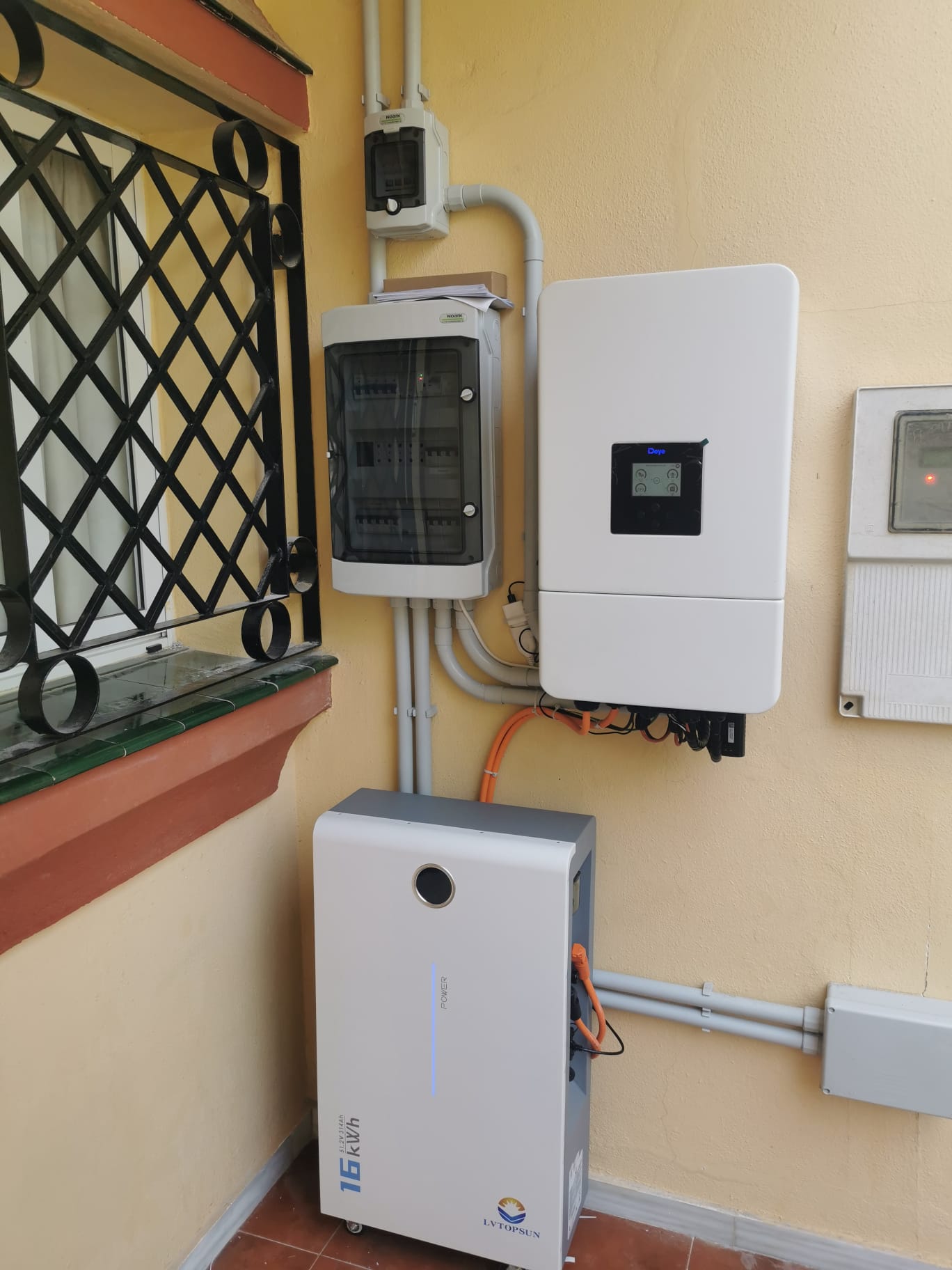 Inversor híbrido instalado en la pared de un cuarto técnico