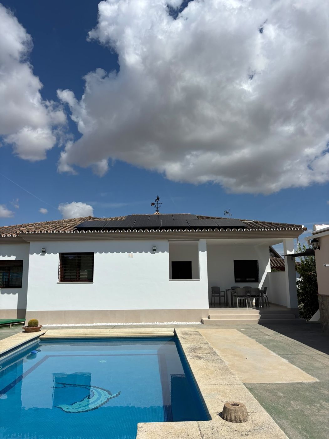 Private home in Coín with 12 AIKO solar panels on the tiled roof, seen from the pool