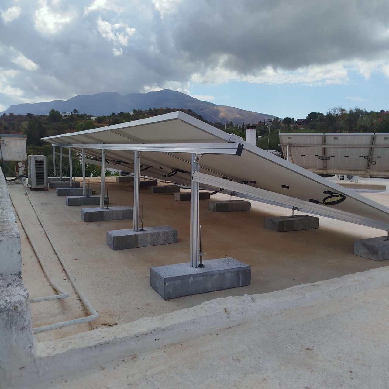 Ballasted aluminium structure with concrete blocks under the solar panels on the roof in Alhaurín de la Torre
