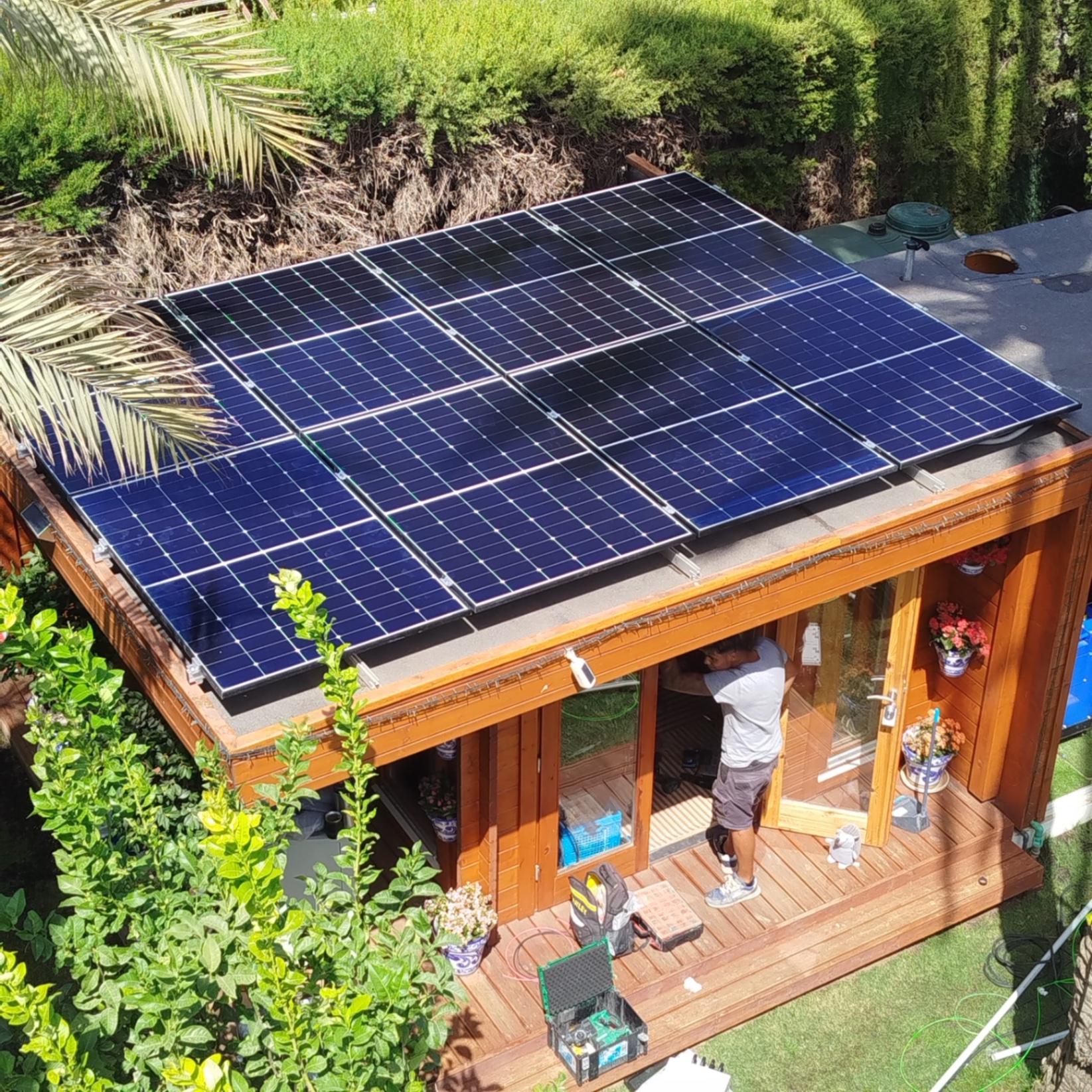 Solar panels on a garden cabin roof being cleaned and optimised, Costa del Sol