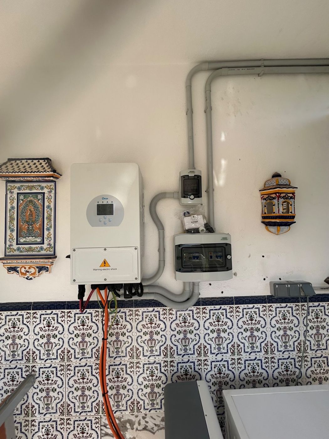 Close-up of the Deye inverter with the protection enclosure and the solar cabling run in conduit